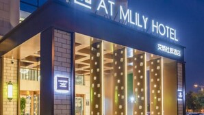The exterior of the Mily Hotel with a modern facade, illuminated signage, and a clear entrance. - Starway Hotel (Shunyi)