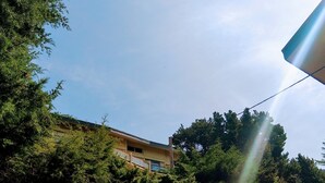 A building surrounded by dense trees with a clear sky. - T2 Duplex with view, Garage, Balcony, Wifi (Font-Romeu-Odeillo-Via)