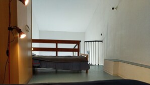 A bedroom with a bunk bed, a wooden headboard, a small bedside table, and a window with a view of the outside. - T2 Duplex with view, Garage, Balcony, Wifi (Font-Romeu-Odeillo-Via)