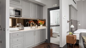 A modern kitchen with grey cabinets, a built-in oven, and a coffee machine. - Hapimag Apartments London (London)