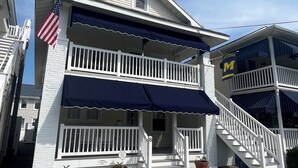 A two-story house with a balcony, a flag, and a sign indicating parking availability. - Peace and quiet within short walking distance to the beach.  (Ocean City)