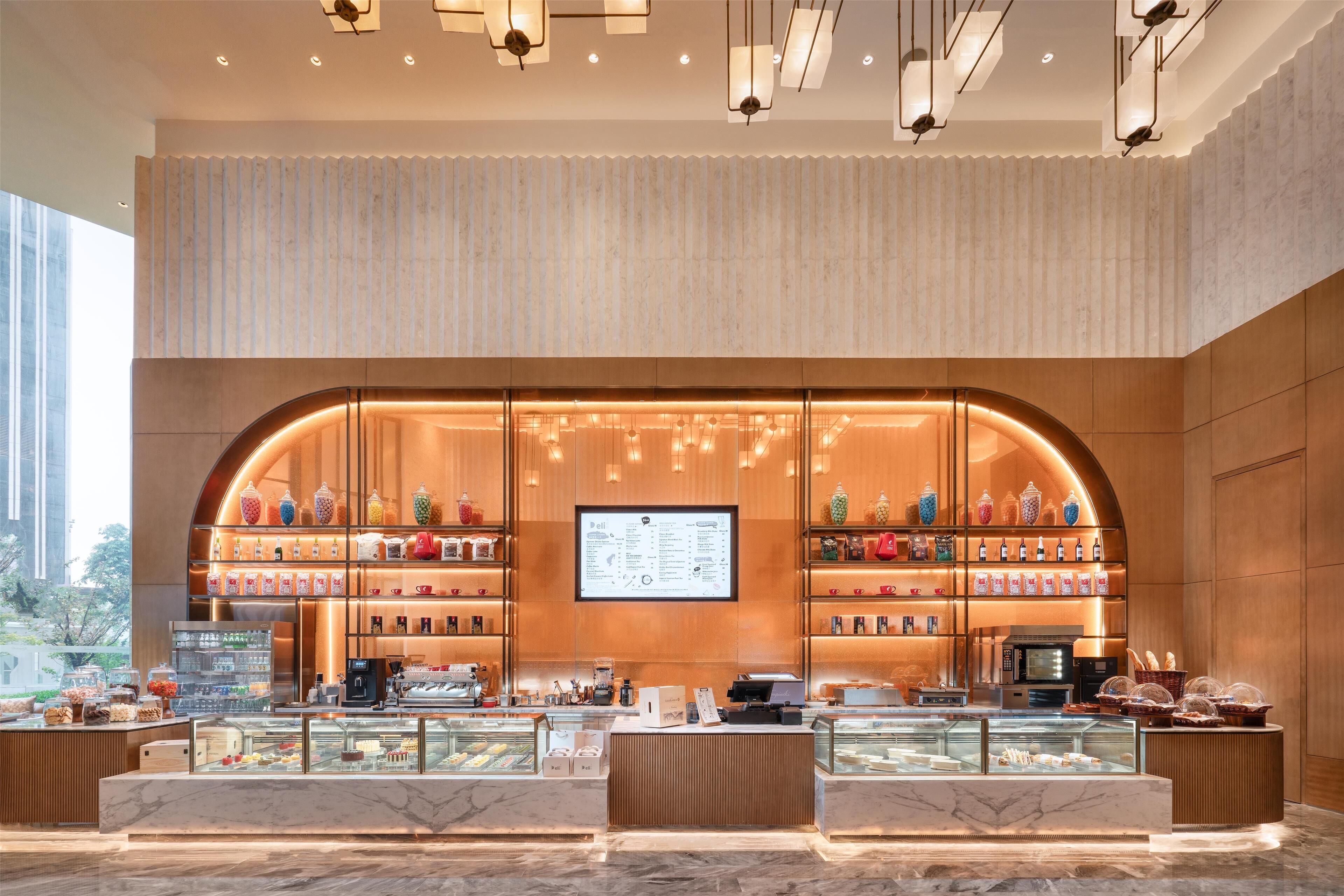 Un café moderne doté d’un menu affiché, de vitrines et d’un comptoir en bois.