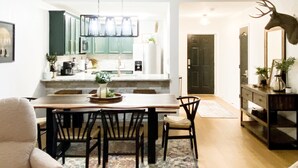 Une cuisine moderne avec un coin repas, un plancher en bois et un lustre.