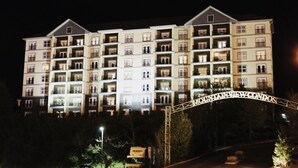 Un hôtel à plusieurs étages doté de balcons, d’une entrée sécurisée et d’une façade bien éclairée.
