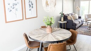A dining area with a round table, chairs, and a vase with flowers. - Updated Condo in A+ Old Town Scottsdale Location! (Scottsdale)