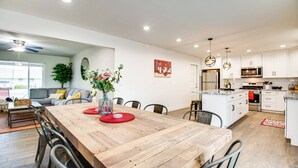 Une cuisine moderne avec des meubles blancs, un îlot central et des appareils en acier inoxydable.