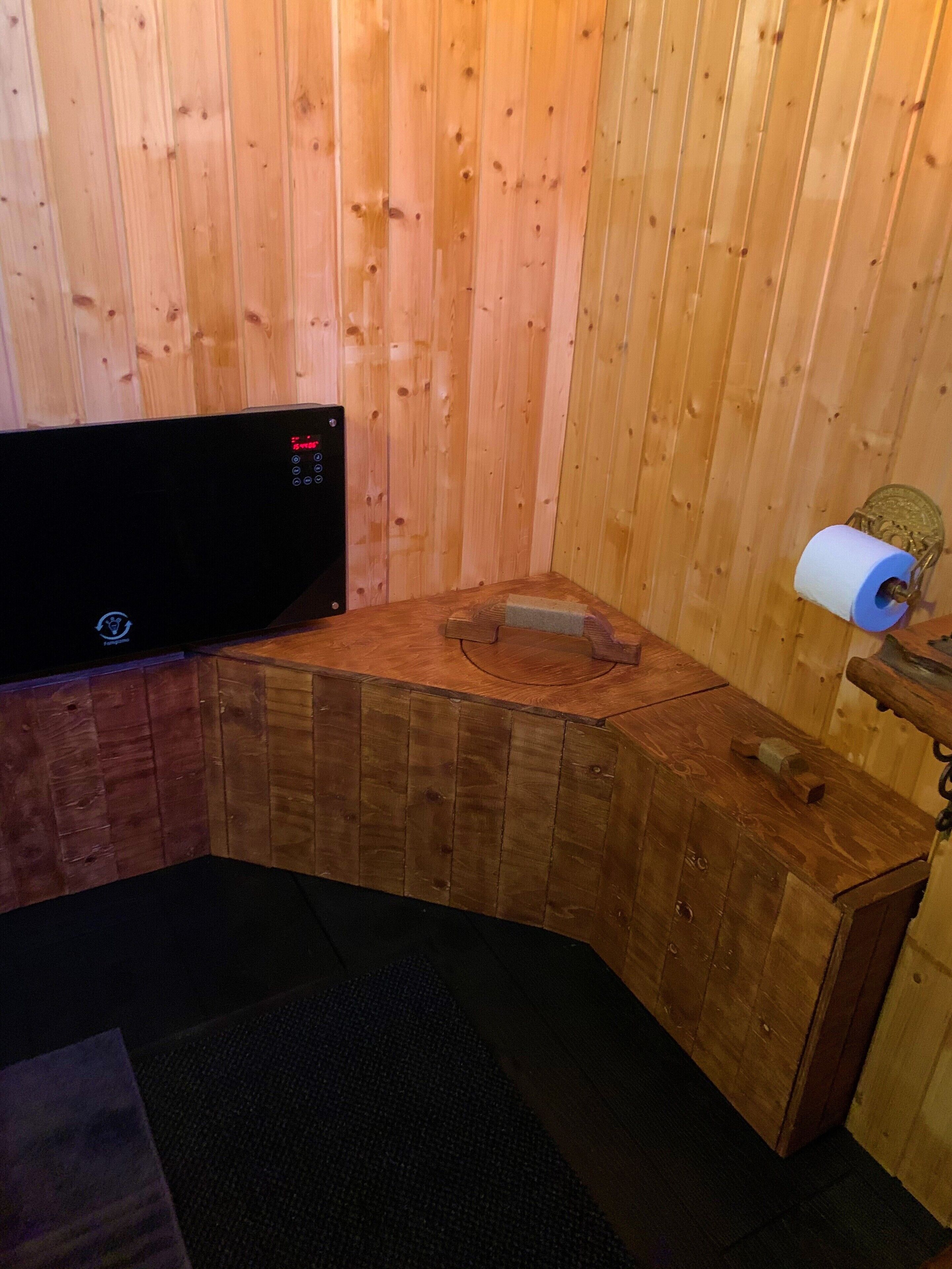 A sauna room with wooden walls and a wooden bench.