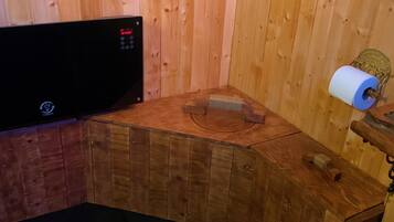 A sauna room with wooden walls and a wooden bench.