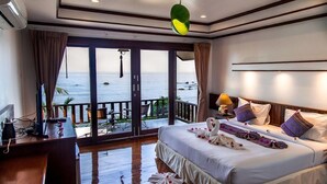 A hotel room with a bed, a desk, and a view of the sea. - Zama Resort (Ko Pha-ngan)