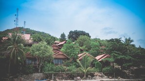 A resort with multiple buildings surrounded by lush greenery and a clear blue sky. - Zama Resort (Ko Pha-ngan)