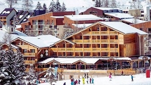 Ein Skigebiet mit Holzhäusern und verschneiter Landschaft.