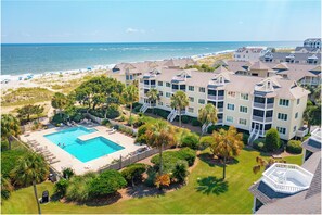 Un hôtel situé en bord de mer, doté d’une piscine, de plusieurs balcons et offrant une vue sur l’océan.