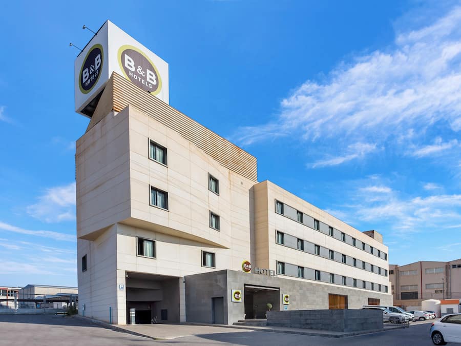 Ein Bed and Breakfast Hotel mit modernem Design, mit einer gut sichtbaren Beschilderung, mehreren Fenstern und einem Parkplatz.