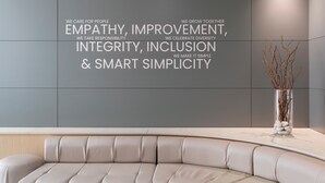 A modern interior with a curved sofa and a wall with motivational text.