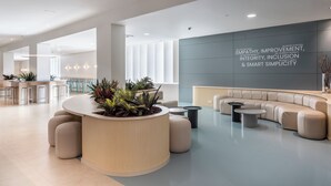 Un moderno mostrador de recepción con forma curva, asientos y una pared decorativa inspiradora.
