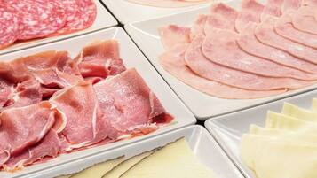 Tagli di salumi e formaggi su vassoi.