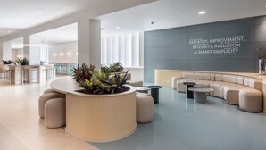 A modern reception area with a curved counter, seating, and a motivational wall.