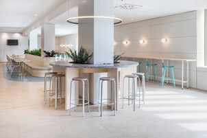 Eine moderne Bar mit einer zentralen Granitinsel, Barhocker und Sitzgelegenheiten.