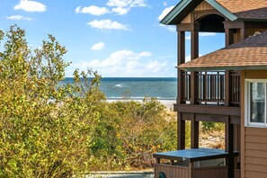 Une terrasse en bois donnant sur une plage, avec vue sur l’océan.