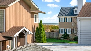 A residential area with two houses, one with a brown siding and another with a beige siding and a blue roof.