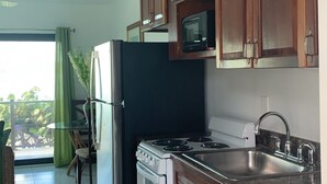 Une cuisine avec des meubles en bois, un évier en acier inoxydable, un réfrigérateur et une cuisinière.