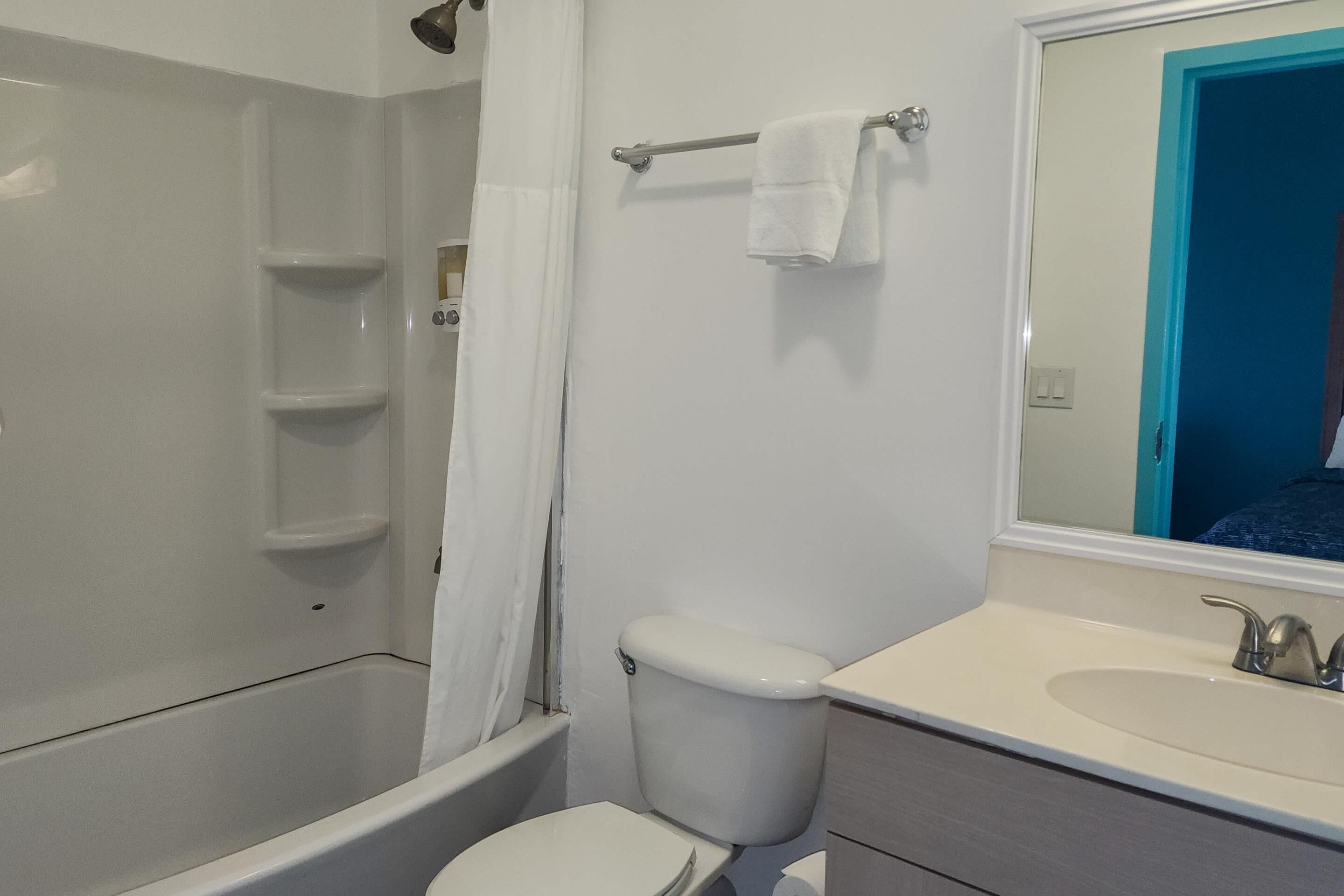 A bathroom with a bathtub, toilet, and sink.
