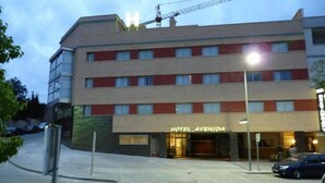 Ein Hotel mit einer glatten Fassade, zahlreichen Fenstern und einem Schild mit der Aufschrift 'HOTEL AVENIDA'.