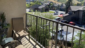 Un balcon donnant sur un parking et des immeubles situés dans une zone vallonnée.
