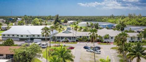 A hotel with multiple buildings, parking areas, and palm trees.