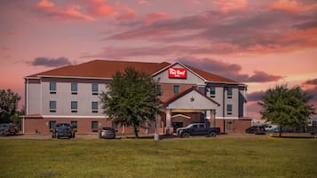 A Red Roof Inn with a brick facade, a covered entrance, and a parking lot.