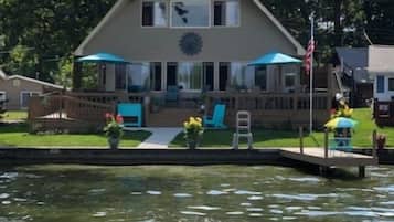 A house with a porch, a small deck, and a water feature in front.