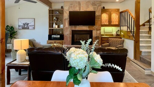 A modern living room with a fireplace, a flat-screen TV, and a staircase. - Shuttle to Resort, Remodeled 1930 sqft, Family Friendly, Large Outdoor Space (Angel Fire)