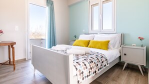 Une chambre à coucher comprenant un lit, une table de chevet, une commode, une fenêtre et une vue sur l’extérieur.