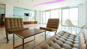 Eine moderne Lobby mit einer Couch, zwei Sesseln und einem Couchtisch.