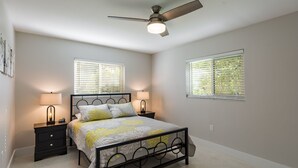 A bedroom with a bed, two bedside tables, a ceiling fan, and two windows with blinds. - Beautiful Home In Gulf Gate - 4 Miles to Siesta Key Beach (Sarasota)