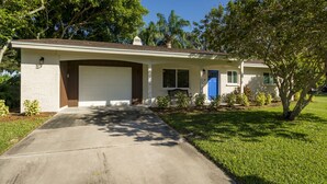 A single-story house with a garage, a front porch, and a small front yard. - Beautiful Home In Gulf Gate - 4 Miles to Siesta Key Beach (Sarasota)