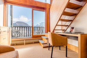Une chambre moderne avec une grande fenêtre, un bureau, une chaise et un escalier.
