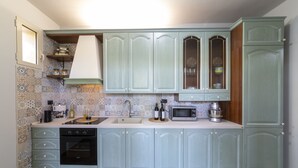 A kitchen with light blue cabinets, a microwave, a sink, and a dishwasher.