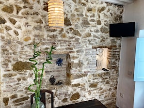 Relax in a cozy space with a flat-screen TV, dining table, and modern lighting.