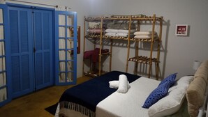 Ein Zimmer mit Etagenbett, einem blauen Kleiderschrank und einem Regal mit gefalteten Handtüchern.