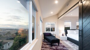 A modern bedroom with a large window, a bed, a bench, and a nightstand. - AMAZING PANORAMIC WATER VIEWS! AC/WATER VIEW DECK/FIRE PIT/BBQ NEW FAMILY RESORT (San Diego)