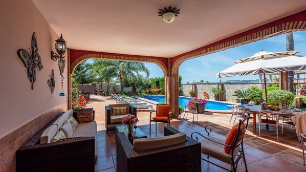 An outdoor patio area with seating, a pool, and a view of the landscape. - Villa Jeroma  Mijas Costa by Ruralidays (Málaga)