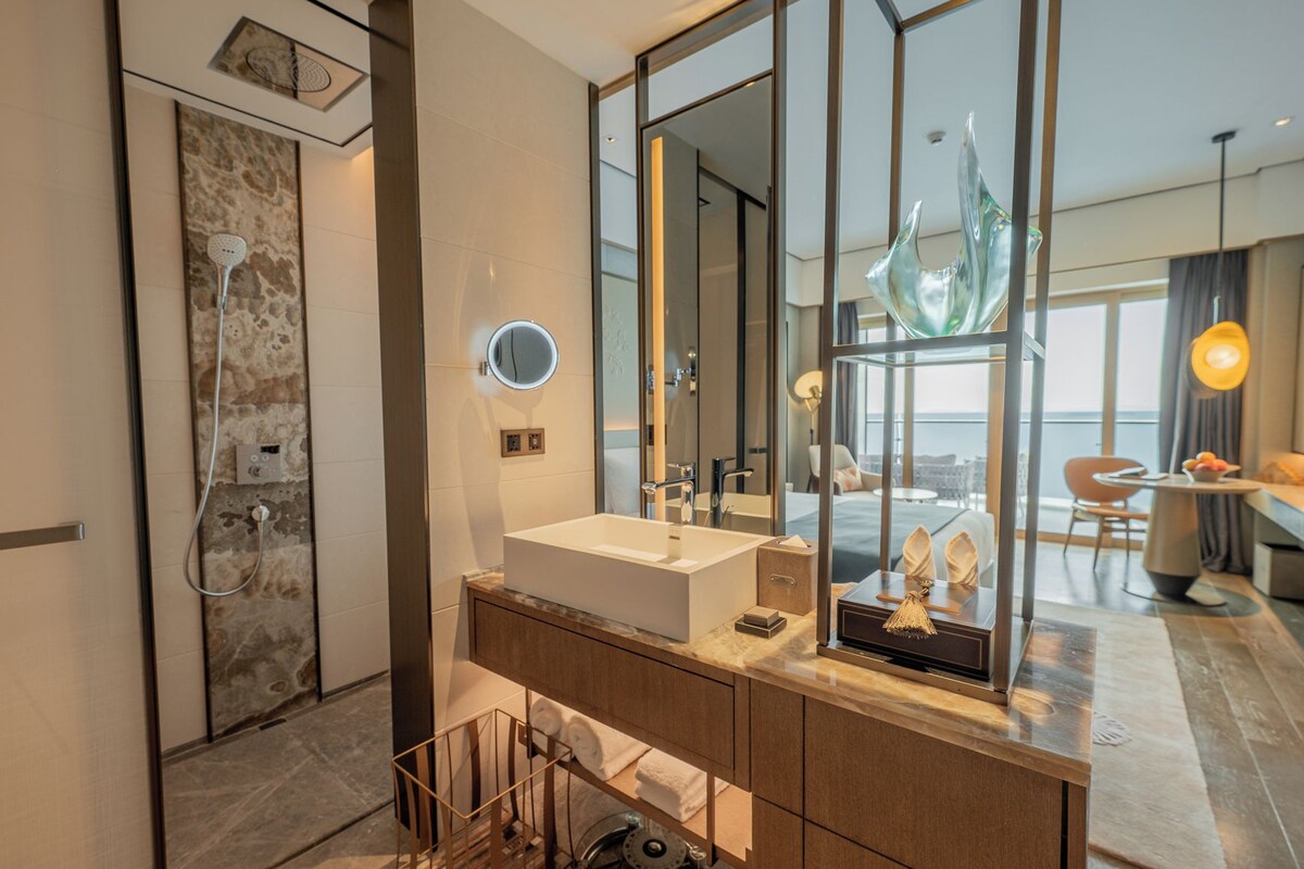 Un baño moderno con un espejo grande, una bañera y una ducha.