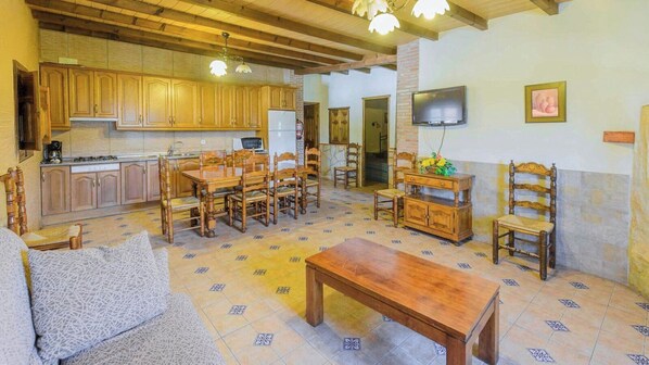 A spacious living area with wooden furniture, a kitchen with wooden cabinets, and a tiled floor. - Casas de Paquita - El Establo Montefrío by Ruralidays (Granada)