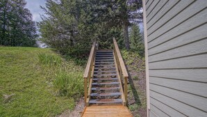 A wooden staircase leading to a house with a siding exterior. - Powderidge 1 Hideaway Slope Side (Snowshoe)