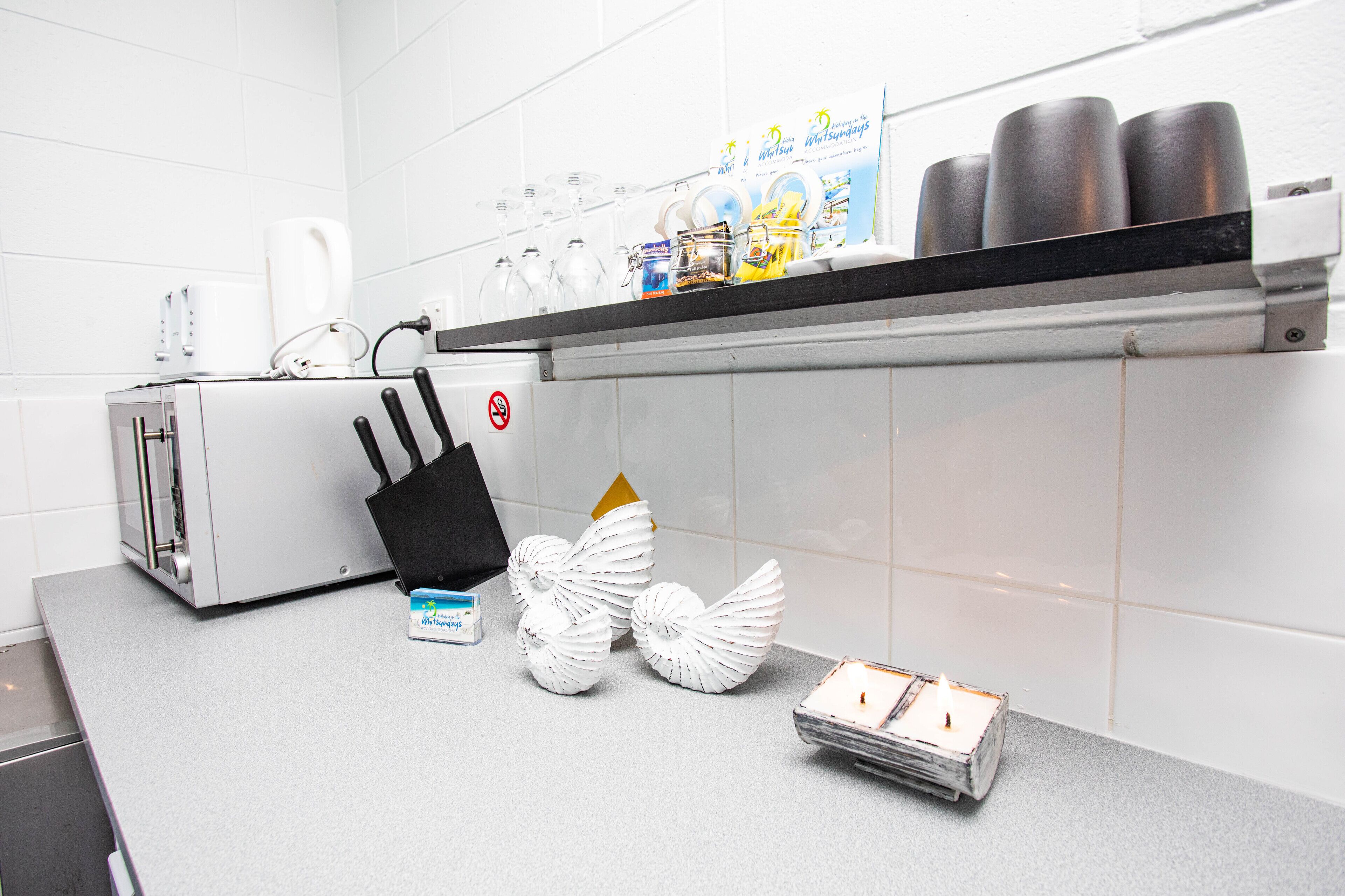 A kitchen with a toaster, a coffee maker, a knife block, and decorative items on the counter.