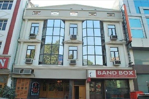 Um edifício com uma grande vitrine e uma placa com o nome 'Band Box' no andar térreo.