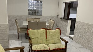 A living room with a sofa set, a coffee table, and a dining area with a table and chairs.
