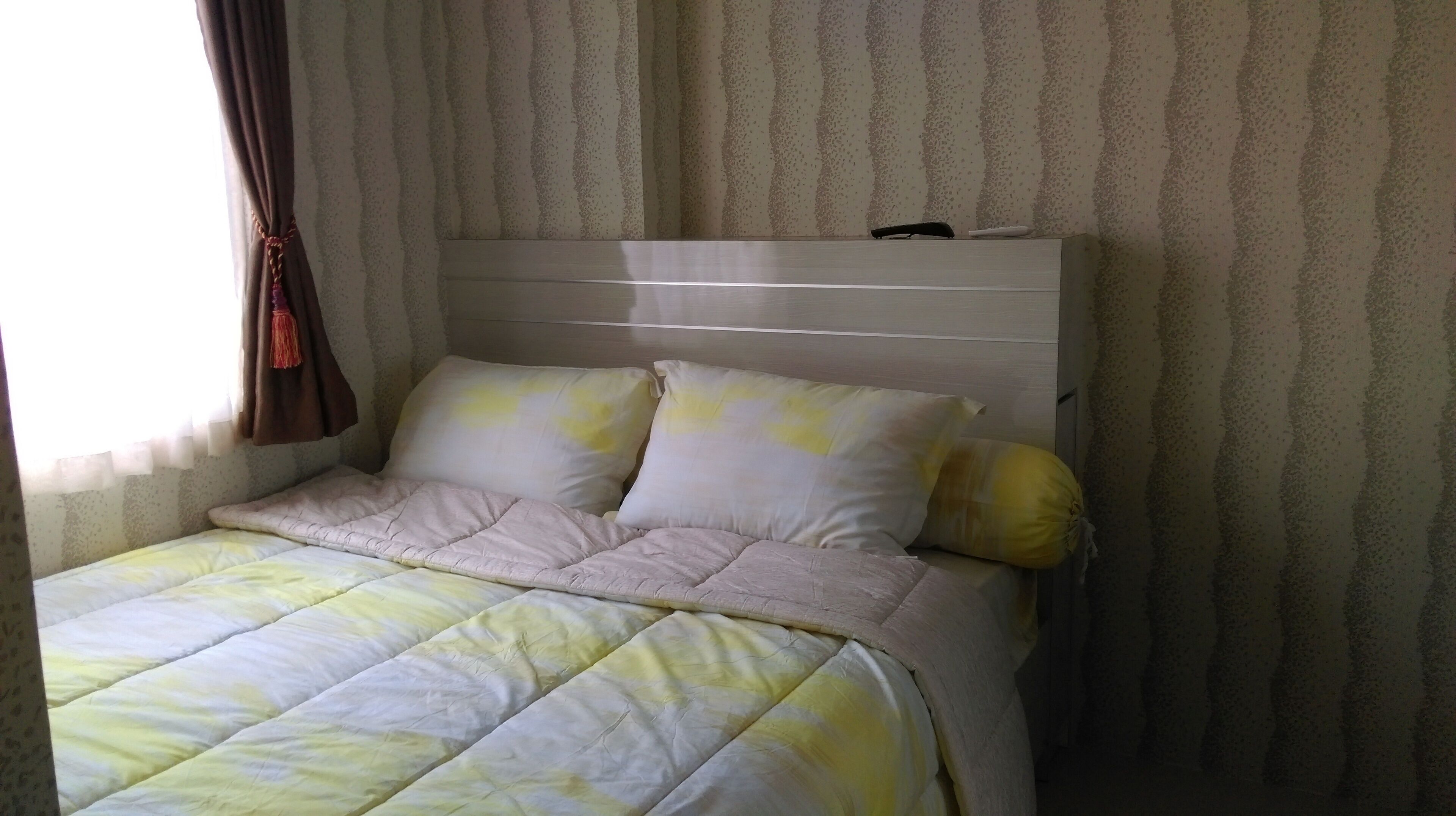 A bed with a headboard, two pillows, and a duvet.
