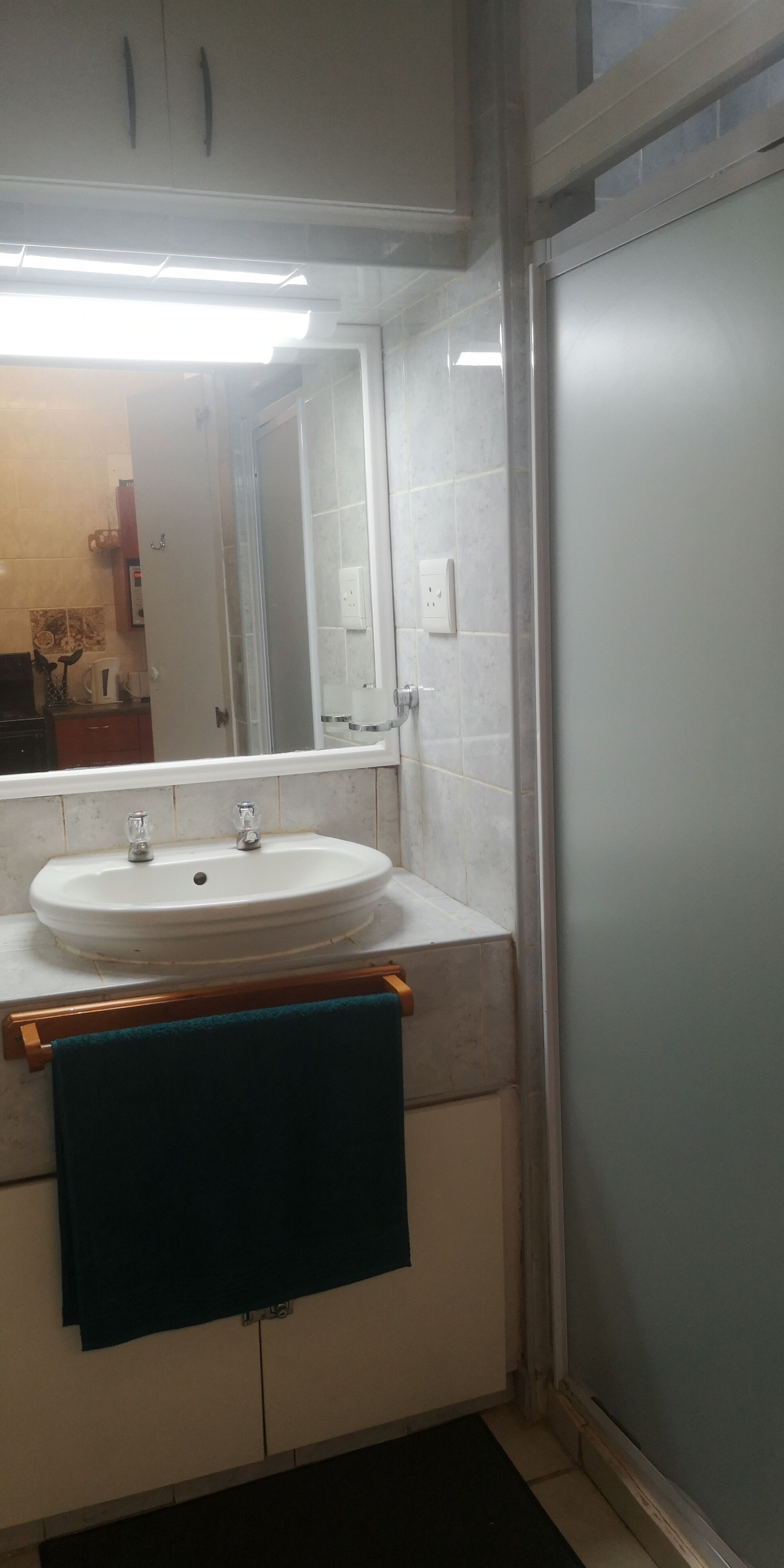A bathroom with a white sink, a mirror, and a towel rack.